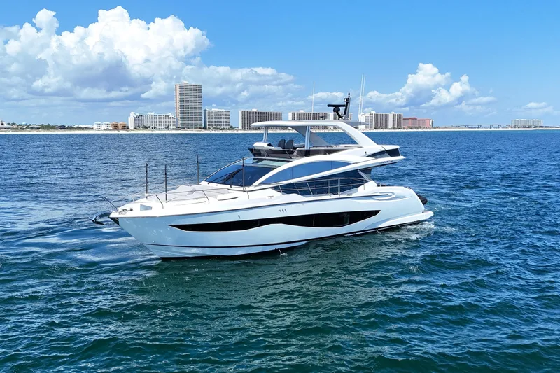 Slide: The Image of Luxury Pearl 62 yacht cruising on ocean, 2022 model, with city skyline backdrop. - 3