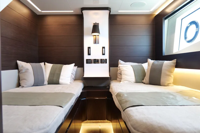 Slide: The Image of Luxurious 2022 Pearl 62 yacht cabin with twin beds, modern lighting, and elegant decor. - 36