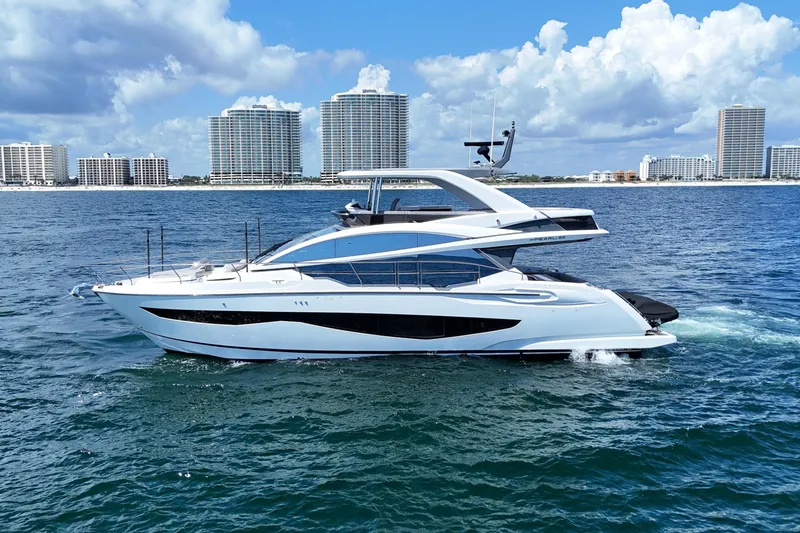Slide: The Image of Luxury Pearl 62 yacht cruising on ocean, 2022 model, with city skyline in background. - 4