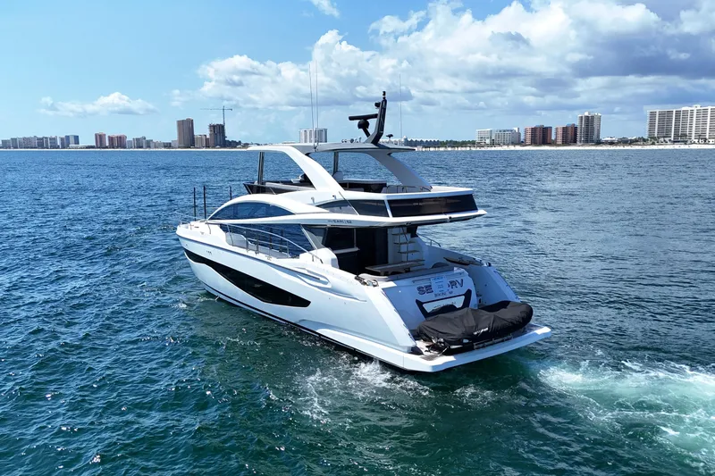 Slide: The Image of Luxury Pearl 62 yacht cruising on ocean, 2022 model, with city skyline in background. - 5