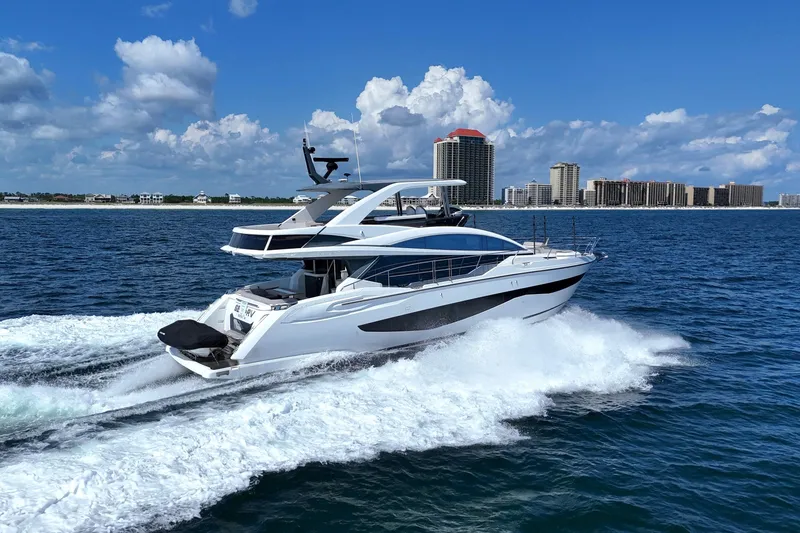 Slide: The Image of 2022 Pearl 62 yacht cruising on ocean with city skyline in background. - 78