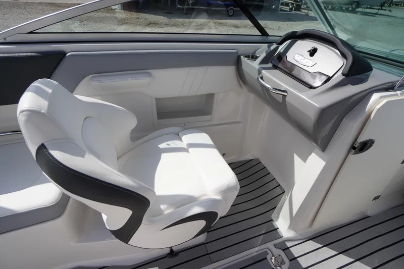 Slide: The Image of 2022 Chaparral 23 SSi OB boat interior with white seating and modern dashboard. - 12