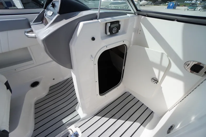 Slide: The Image of 2022 Chaparral 23 SSi OB boat interior with open storage compartment and sleek design. - 18