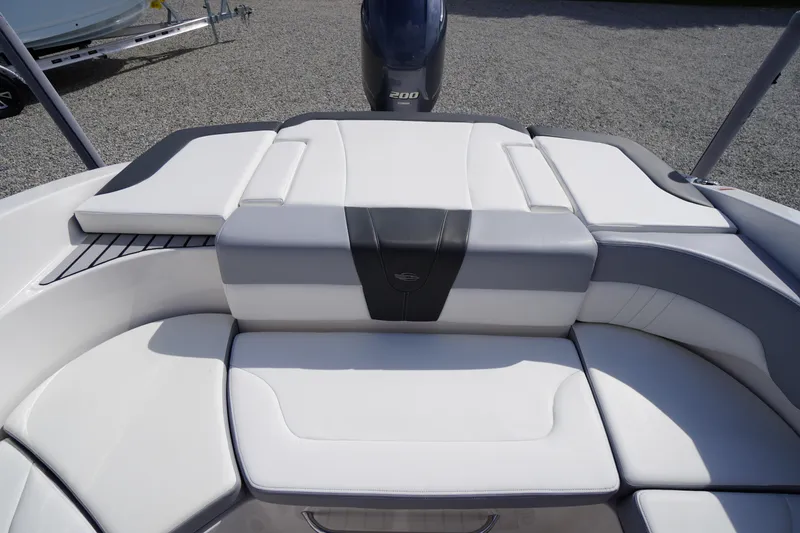 Slide: The Image of 2022 Chaparral 23 SSi OB boat interior with white cushioned seating and sleek design. - 23