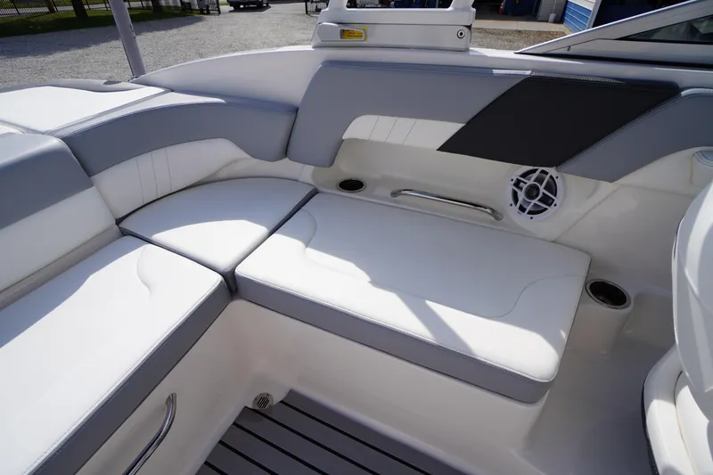 Slide: The Image of 2022 Chaparral 23 SSi OB boat interior with white cushioned seating and speaker. - 25
