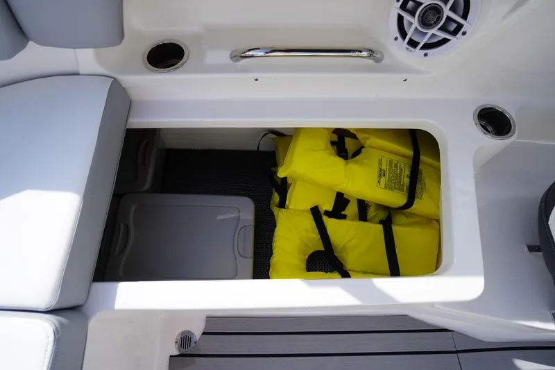 Slide: The Image of Storage compartment with yellow life jackets on a 2022 Chaparral 23 SSi OB boat. - 29