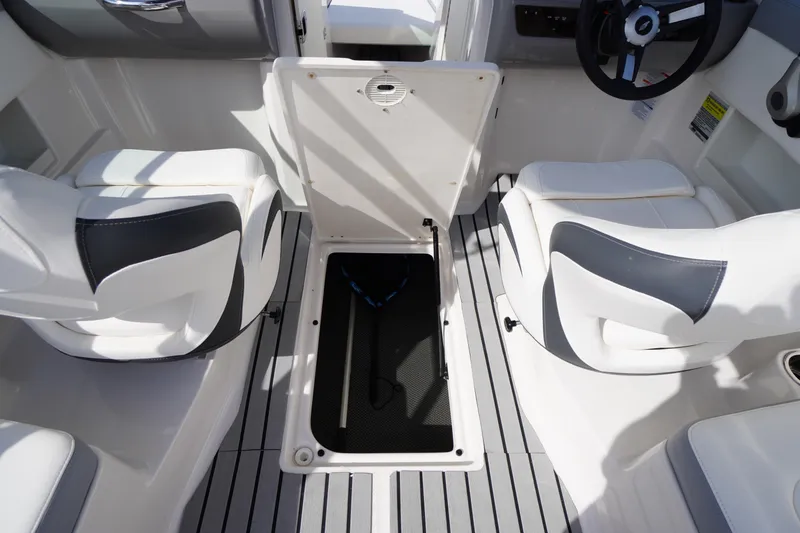 Slide: The Image of 2022 Chaparral 23 SSi OB boat interior with open storage compartment and seating. - 31