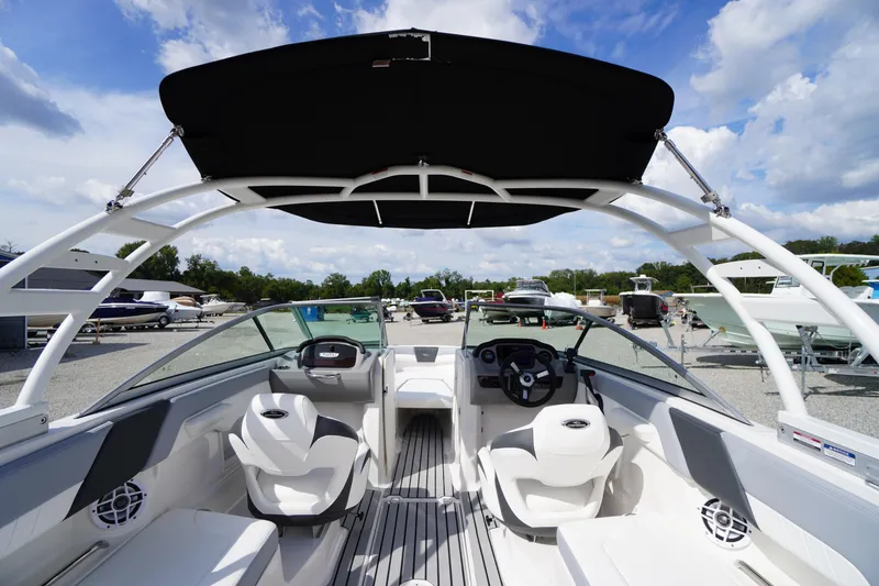 Slide: The Image of 2022 Chaparral 23 SSi OB boat interior with seating and steering wheel under a canopy. - 41