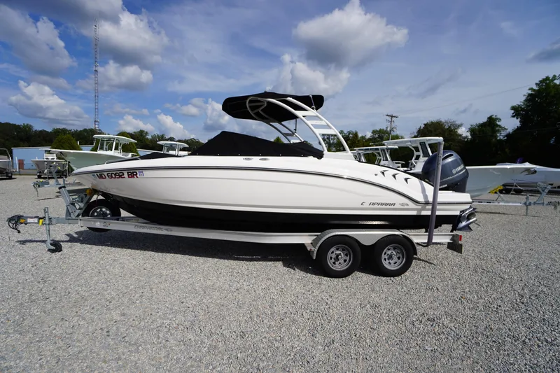 Slide: The Image of 2022 Chaparral 23 SSi OB boat on trailer, parked outdoors under a blue sky. - 46