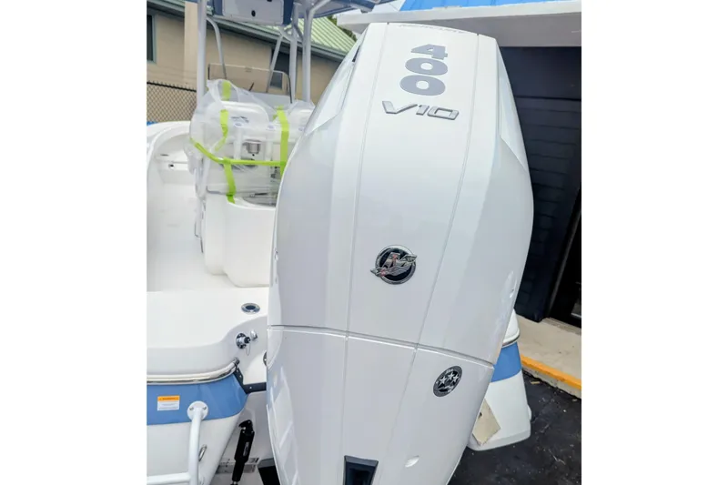 Slide: The Image of 2026 BlackJack 256 Coastal boat with powerful outboard motor in a sunny marina setting. - 10