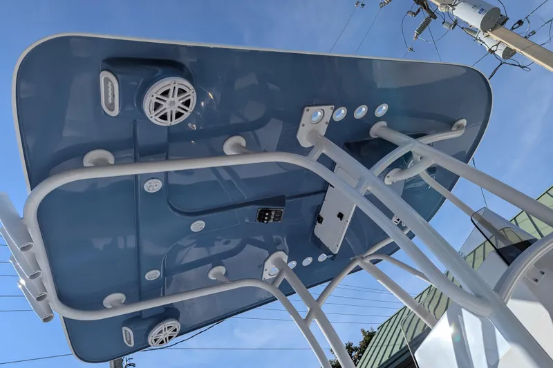 Slide: The Image of 2026 BlackJack 256 Coastal boat with rod holders and steering console, docked outdoors. - 6