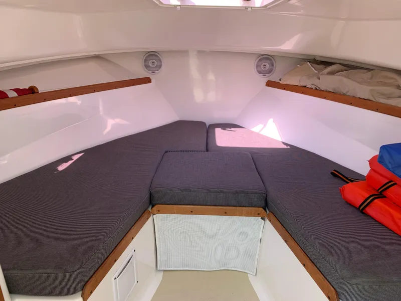 Slide: The Image of 2004 Hunt Yachts Surfhunter 25 cabin interior with cushioned seating and storage. - 15