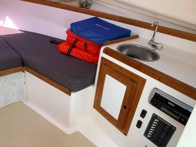 Slide: The Image of 2004 Hunt Yachts Surfhunter 25 interior with sink, cushions, and storage. - 16