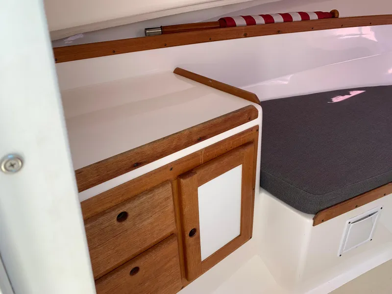 Slide: The Image of 2004 Hunt Yachts Surfhunter 25 cabin interior with wooden cabinetry and cushioned seating. - 17