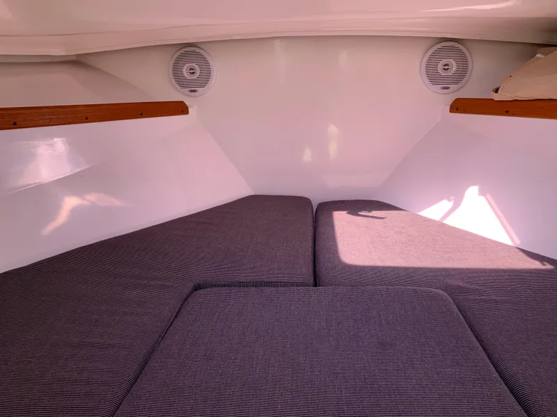 Slide: The Image of 2004 Hunt Yachts Surfhunter 25 cabin interior with cushioned seating and wooden accents. - 19
