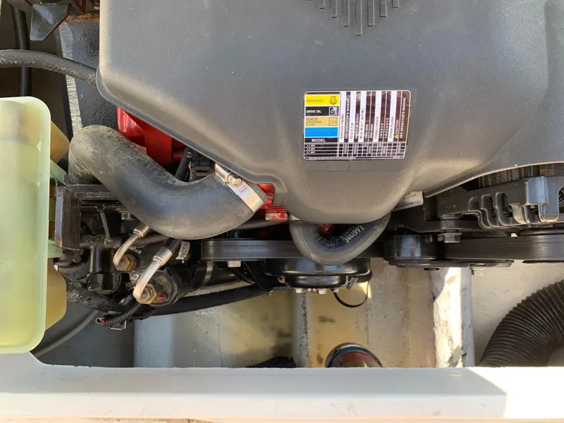 Slide: The Image of Engine compartment of a 2004 Hunt Yachts Surfhunter 25, showcasing mechanical components and labels. - 23