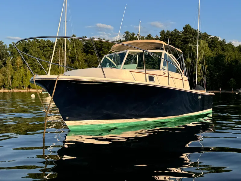 Slide: The Image of 2004 Hunt Yachts Surfhunter 25 on calm water, surrounded by trees and clear sky. - 27