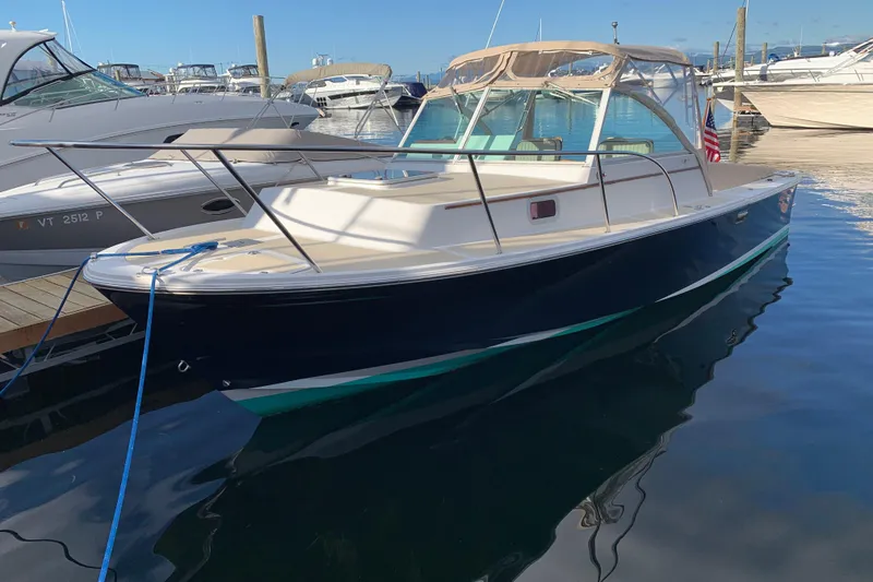 Slide: The Image of 2004 Hunt Yachts Surfhunter 25 docked in marina, sleek design, calm water reflection. - 28