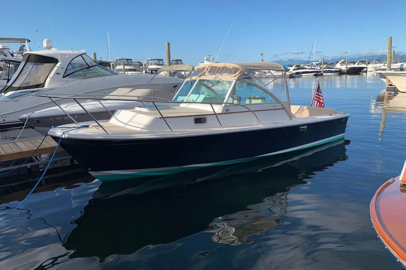 Slide: The Image of 2004 Hunt Yachts Surfhunter 25 docked in a marina, reflecting on calm water. - 29