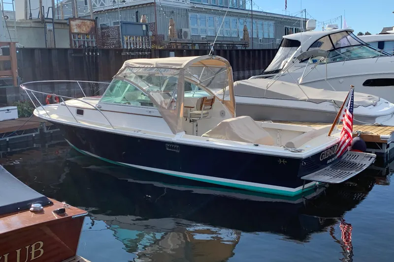 Slide: The Image of 2004 Hunt Yachts Surfhunter 25 docked, featuring a sleek design and American flag. - 30