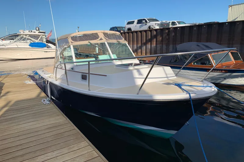 Slide: The Image of 2004 Hunt Yachts Surfhunter 25 docked at marina, featuring sleek design and blue hull. - 33