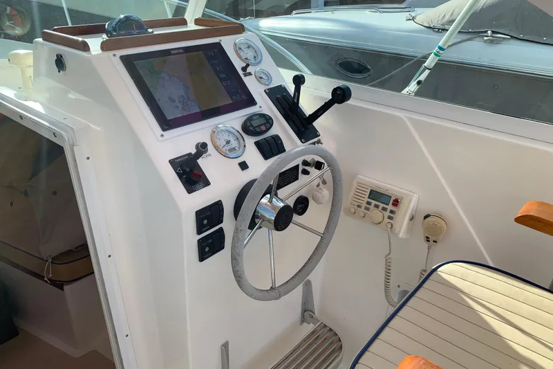 Slide: The Image of 2004 Hunt Yachts Surfhunter 25 helm with navigation controls and steering wheel. - 35
