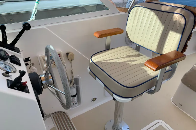 Slide: The Image of 2004 Hunt Yachts Surfhunter 25 helm with steering wheel and cushioned captain's chair. - 38