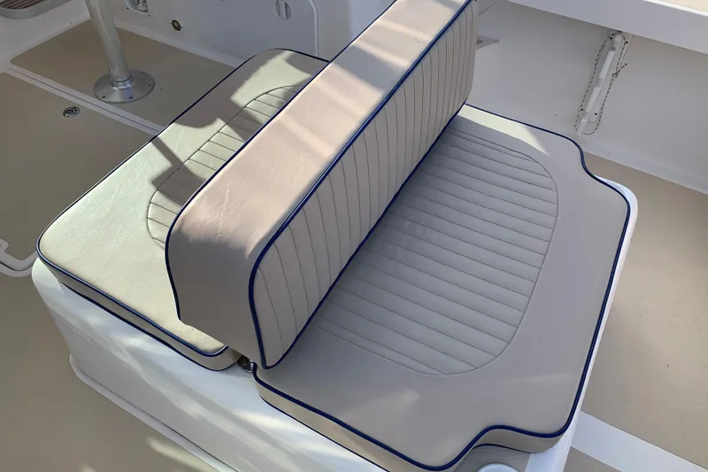 Slide: The Image of Cushioned seating on 2004 Hunt Yachts Surfhunter 25, featuring beige upholstery with blue trim. - 43