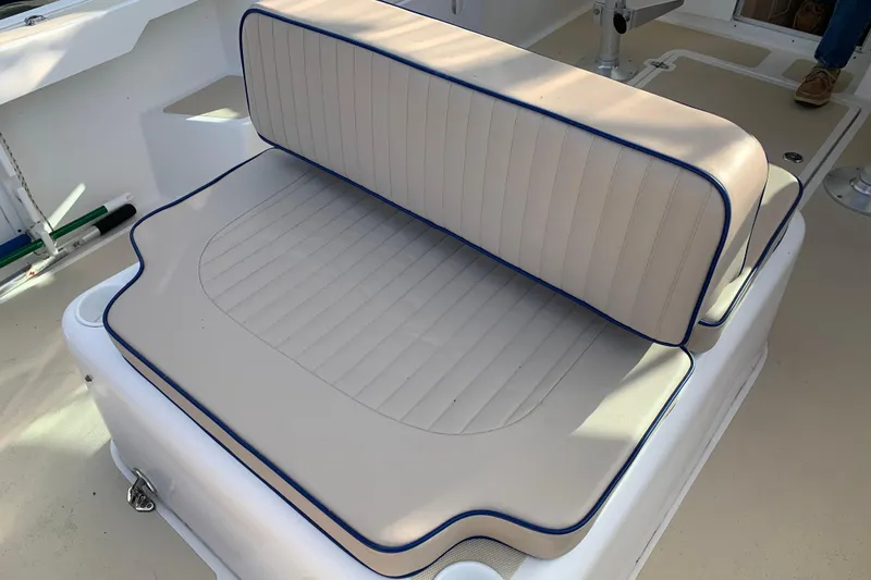 Slide: The Image of Cushioned seating on 2004 Hunt Yachts Surfhunter 25, featuring beige upholstery with blue trim. - 44
