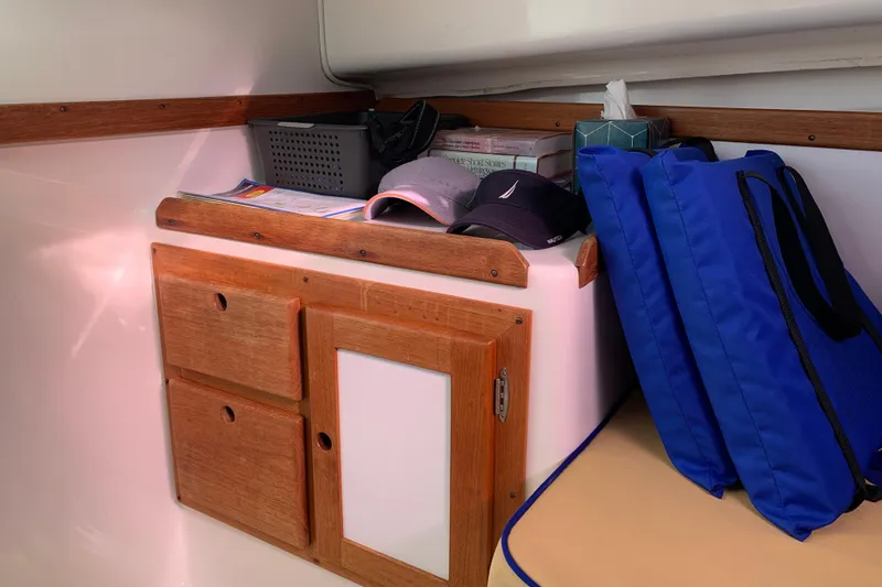 Slide: The Image of Interior of 2004 Hunt Yachts Surfhunter 25 with storage, hats, and blue bags. - 48