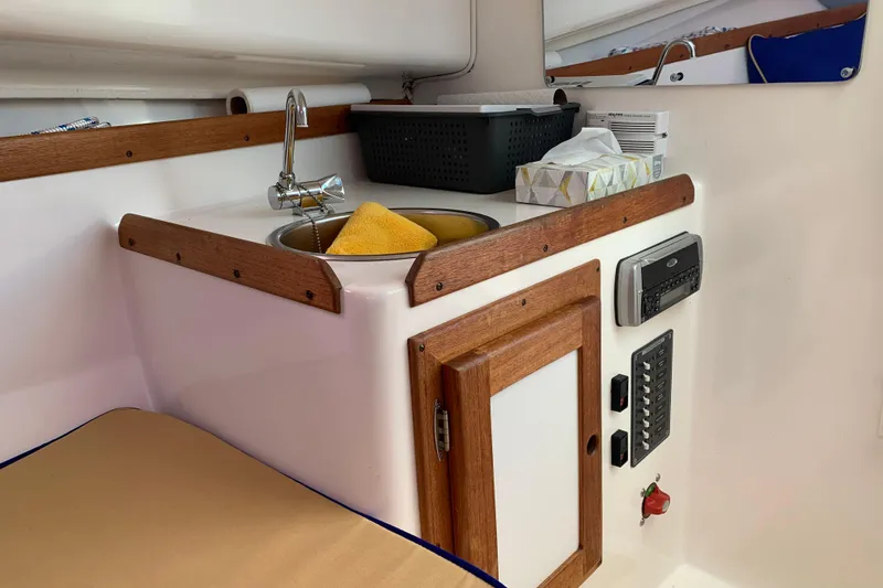 Slide: The Image of 2004 Hunt Yachts Surfhunter 25 interior with sink, wooden cabinetry, and control panel. - 49
