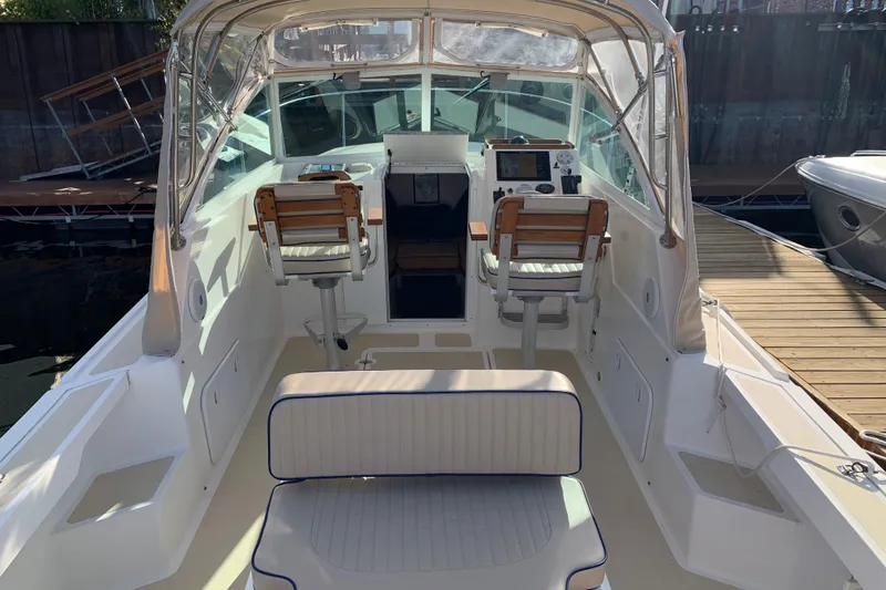 Slide: The Image of 2004 Hunt Yachts Surfhunter 25 interior with helm and seating, docked at marina. - 52