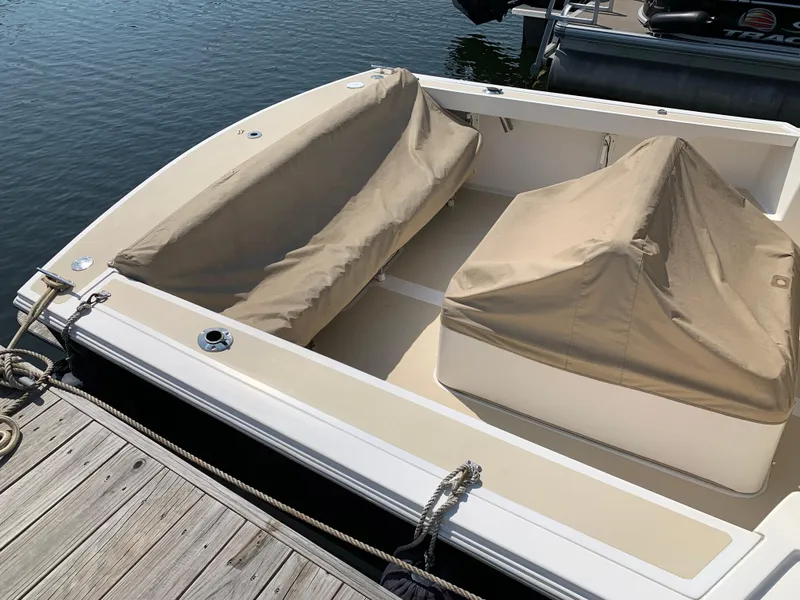 Slide: The Image of 2004 Hunt Yachts Surfhunter 25 docked, featuring beige covers and sleek design. - 9