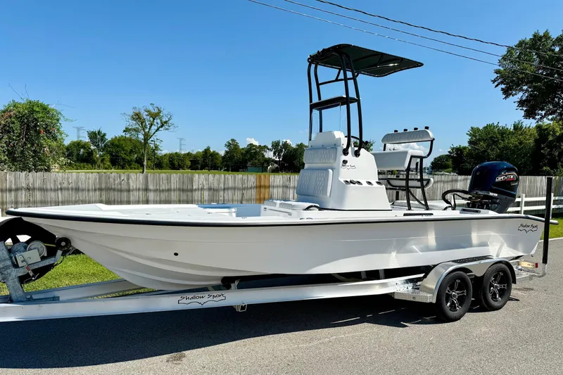 The Image of 2026 Shallow Sport 24 Modified V boat on trailer, parked outdoors. - 1