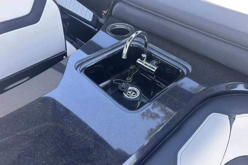 Slide: The Image of 2025 Yamaha Boats 275SD interior sink with sleek black countertop and chrome faucet. - 22
