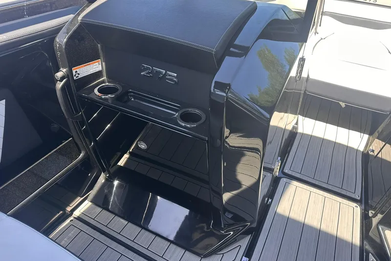 Slide: The Image of 2025 Yamaha Boats 275SD interior with sleek black design and cup holders. - 25