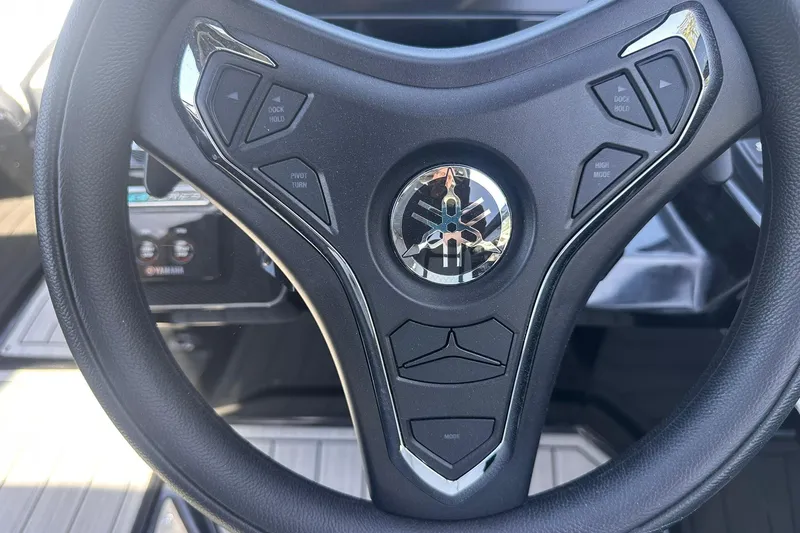 Slide: The Image of Steering wheel of 2025 Yamaha Boats 275SD with control buttons and logo. - 32