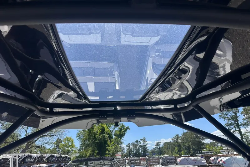 Slide: The Image of 2025 Yamaha Boats 275SD with sleek, modern design and transparent roof under sunny sky. - 44