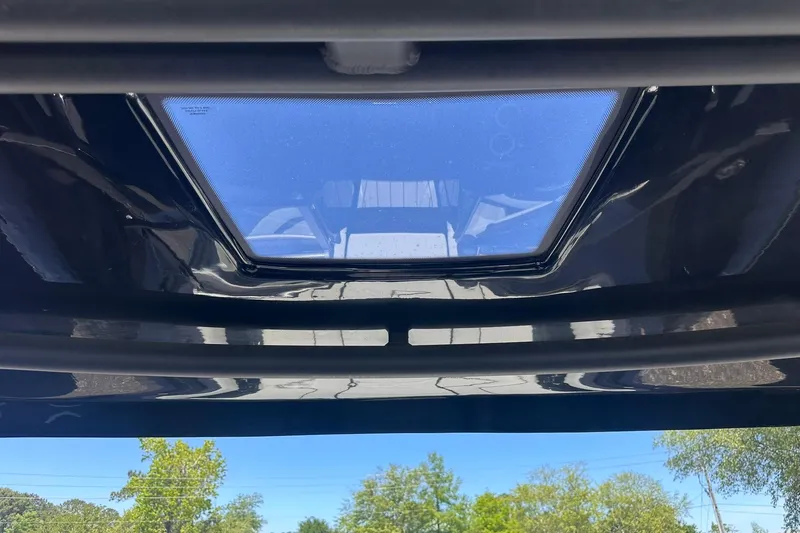 Slide: The Image of 2025 Yamaha Boats 275SD sunroof view with clear blue sky and trees. - 47