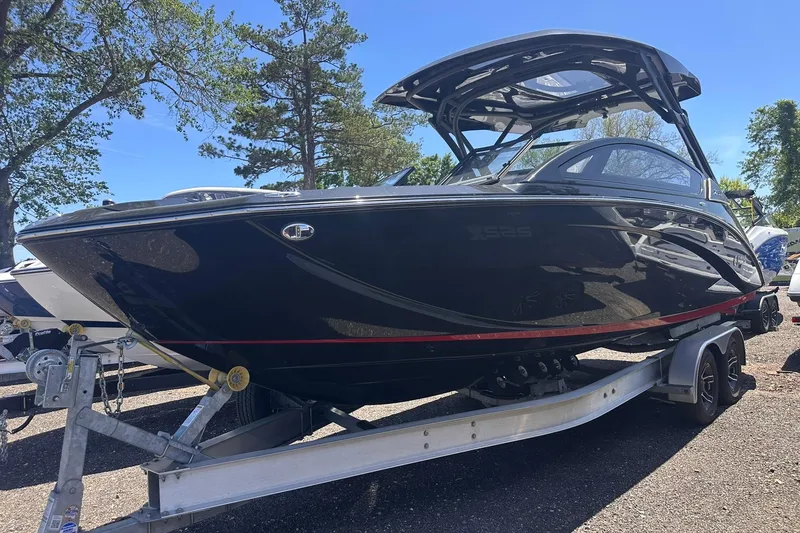 Slide: The Image of 2025 Yamaha Boats 275SD on trailer, sleek black design, parked outdoors. - 51