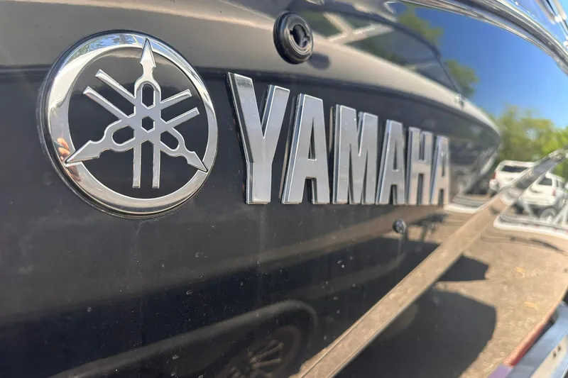 Slide: The Image of Close-up of 2025 Yamaha Boats 275SD logo on sleek black surface. - 52
