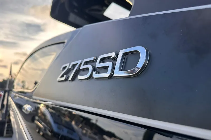 Slide: The Image of 2025 Yamaha Boats 275SD logo on sleek black surface at sunset. - 9