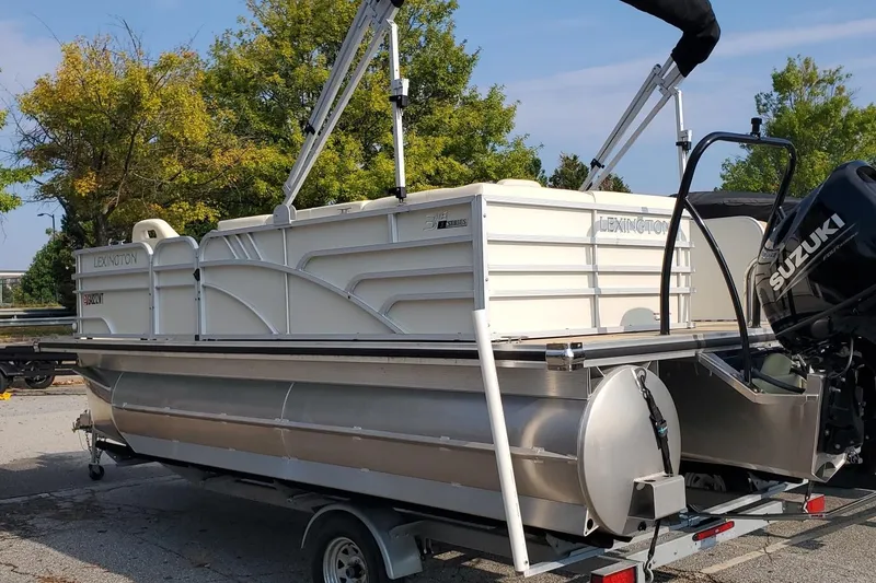 Slide: The Image of 2023 Lexington 318s pontoon boat on trailer with Suzuki outboard motor. - 2
