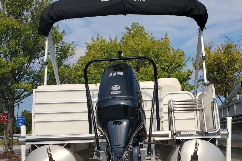 Slide: The Image of 2023 Lexington 318s pontoon boat with 115 HP engine, parked outdoors. - 3