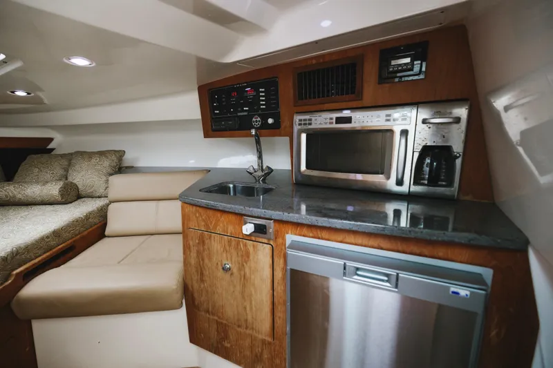 Slide: The Image of 2008 Everglades 350LX cabin interior with kitchenette, microwave, sink, and seating area. - 13