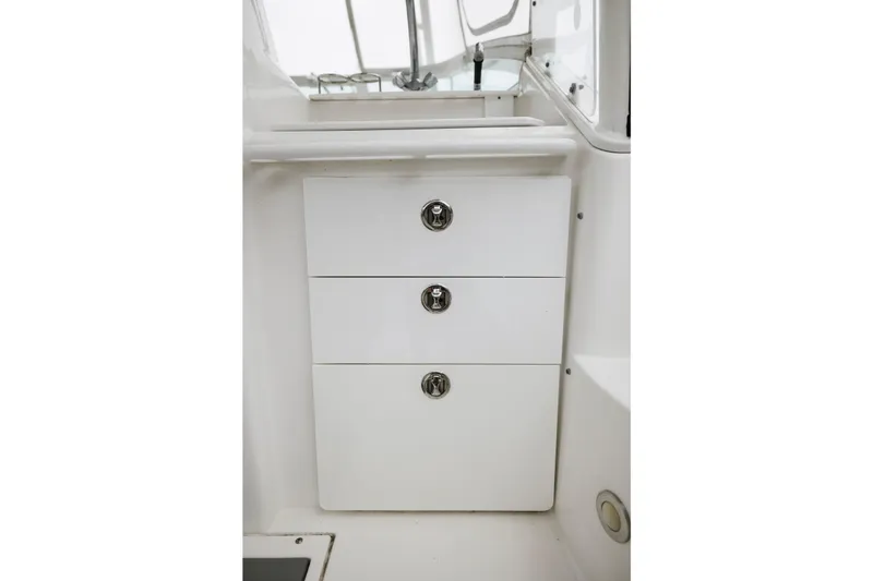Slide: The Image of 2008 Everglades 350LX boat interior with three white storage drawers. - 20