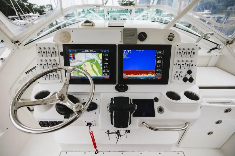 Slide: The Image of Control panel of a 2008 Everglades 350LX boat with navigation screens and steering wheel. - 23