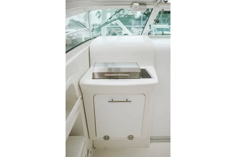 Slide: The Image of 2008 Everglades 350LX boat interior with built-in grill and storage cabinet. - 32