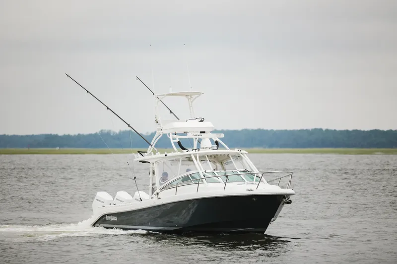 Slide: The Image of 2008 Everglades 350LX boat cruising on a calm lake with fishing rods. - 4
