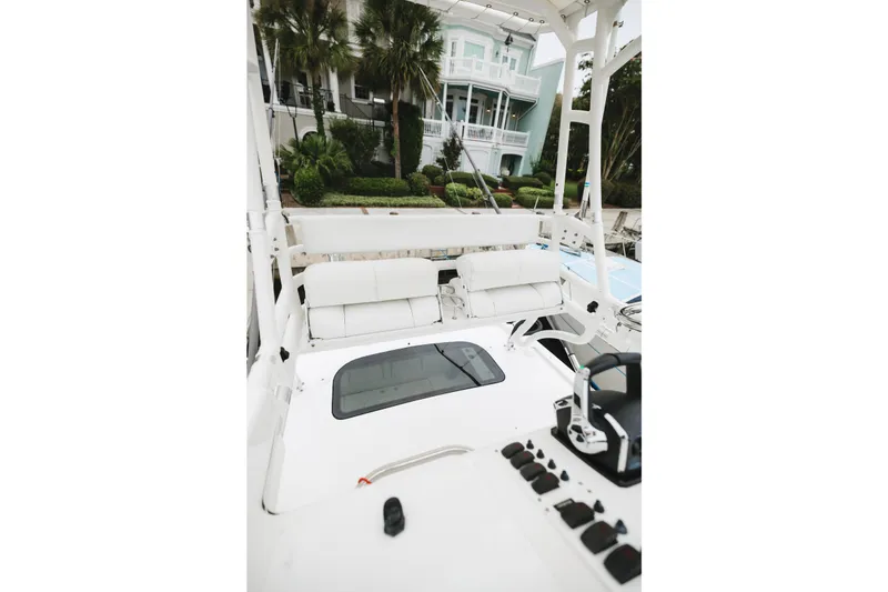 Slide: The Image of 2008 Everglades 350LX boat interior with helm, white seating, and lush greenery backdrop. - 40